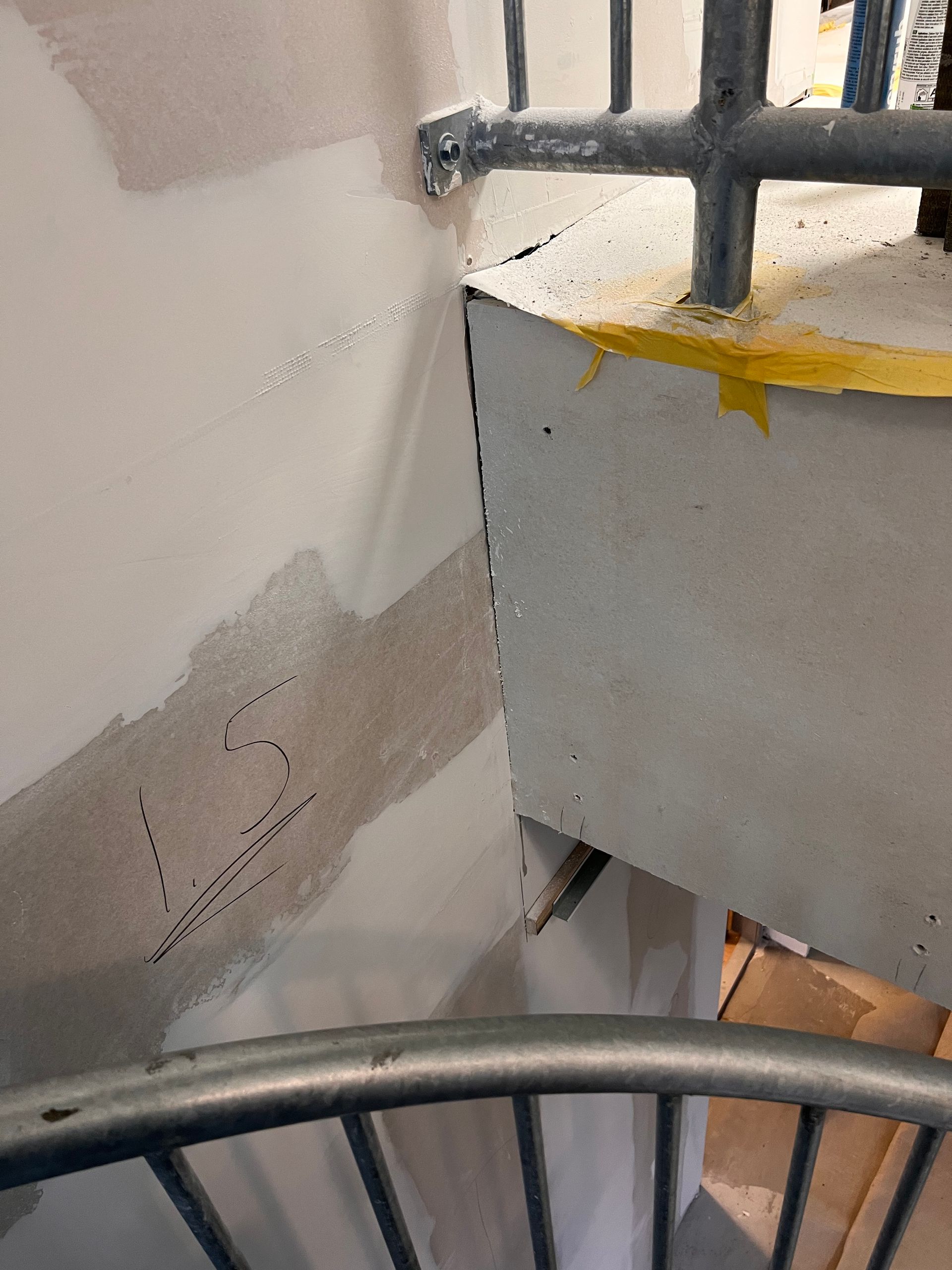 het getal 15 staat op een muur naast een metalen reling geschreven