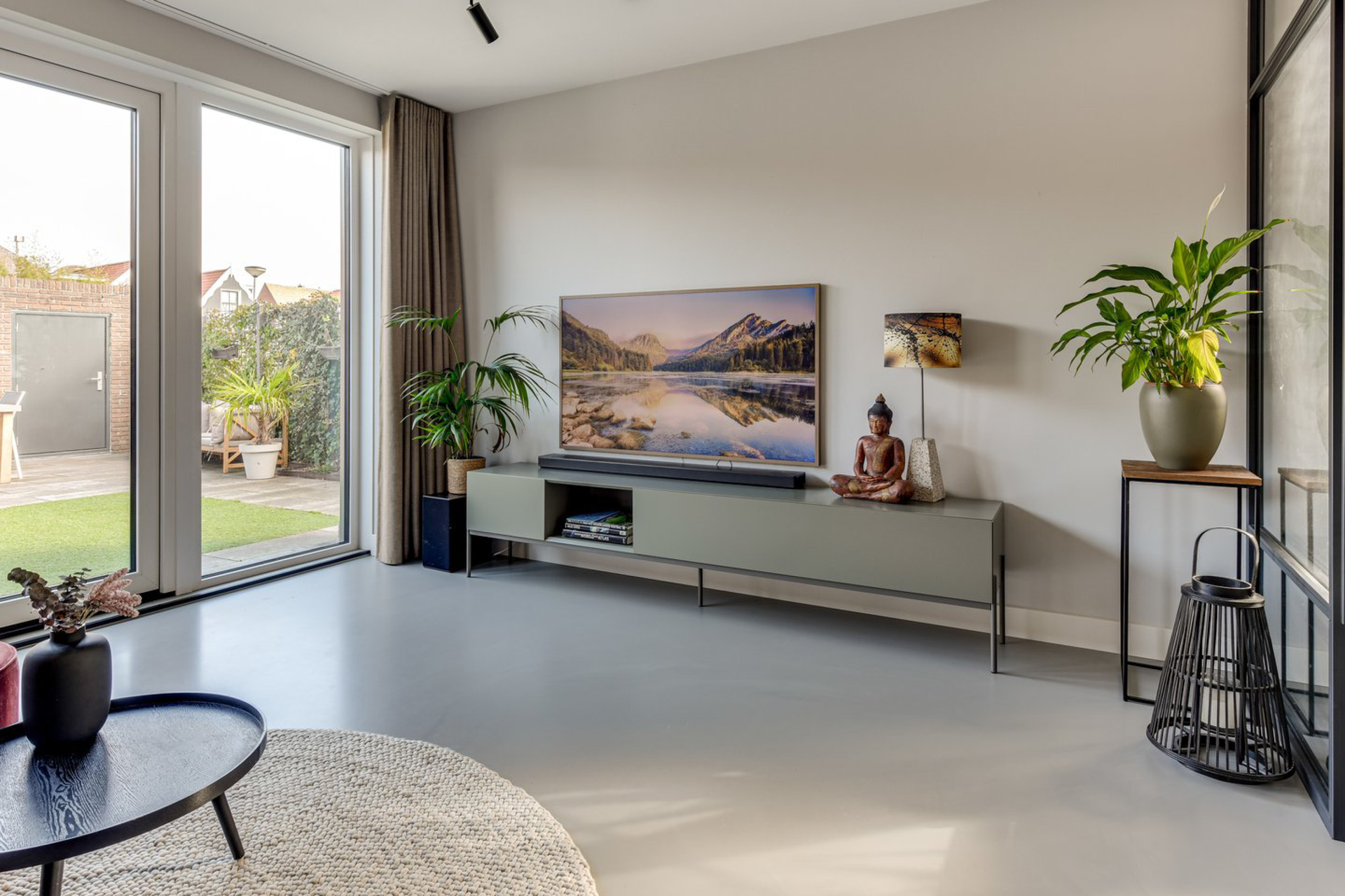 Een woonkamer met een grote flatscreen-tv aan de muur.