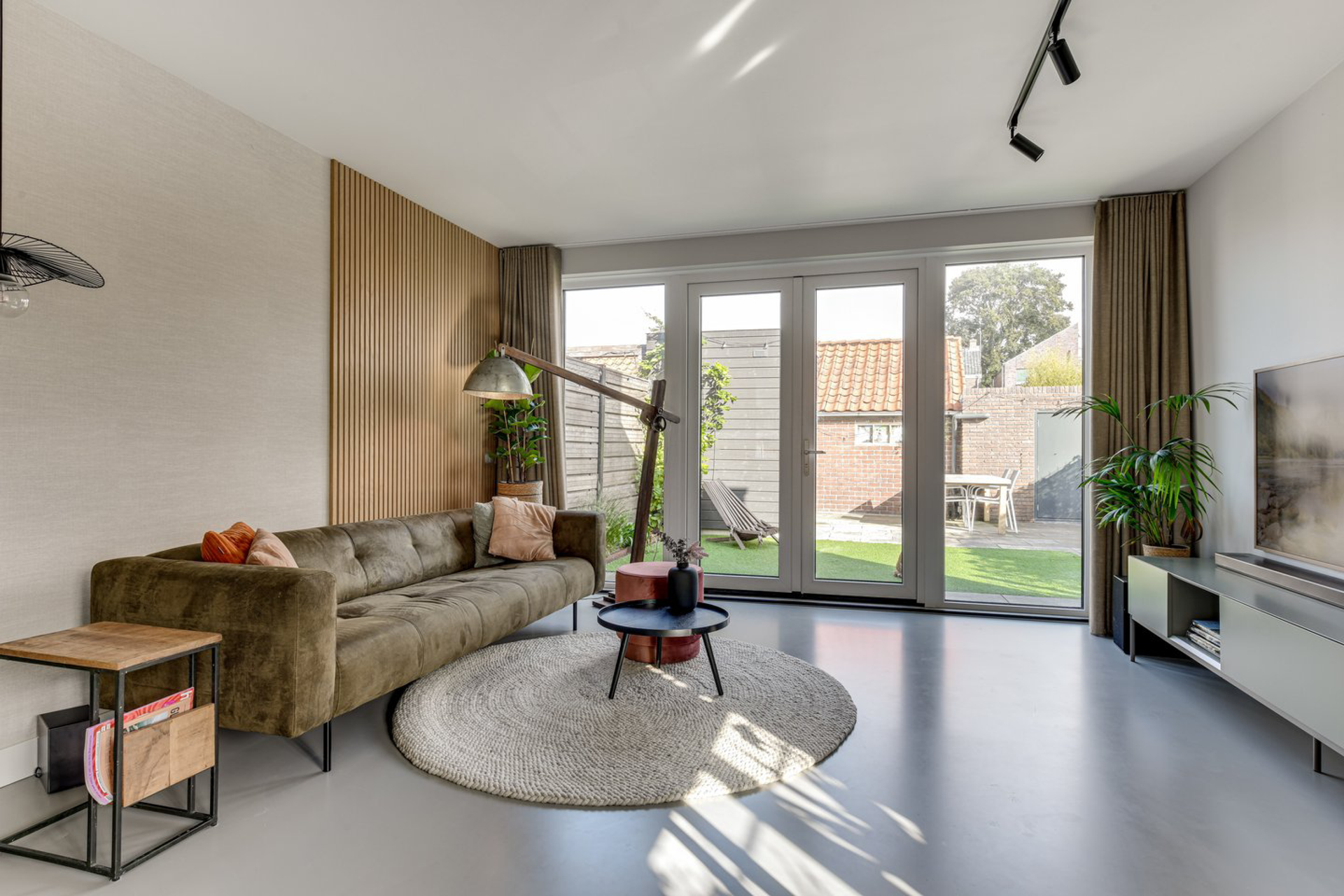 Een woonkamer met een bank, een tafel en een televisie.
