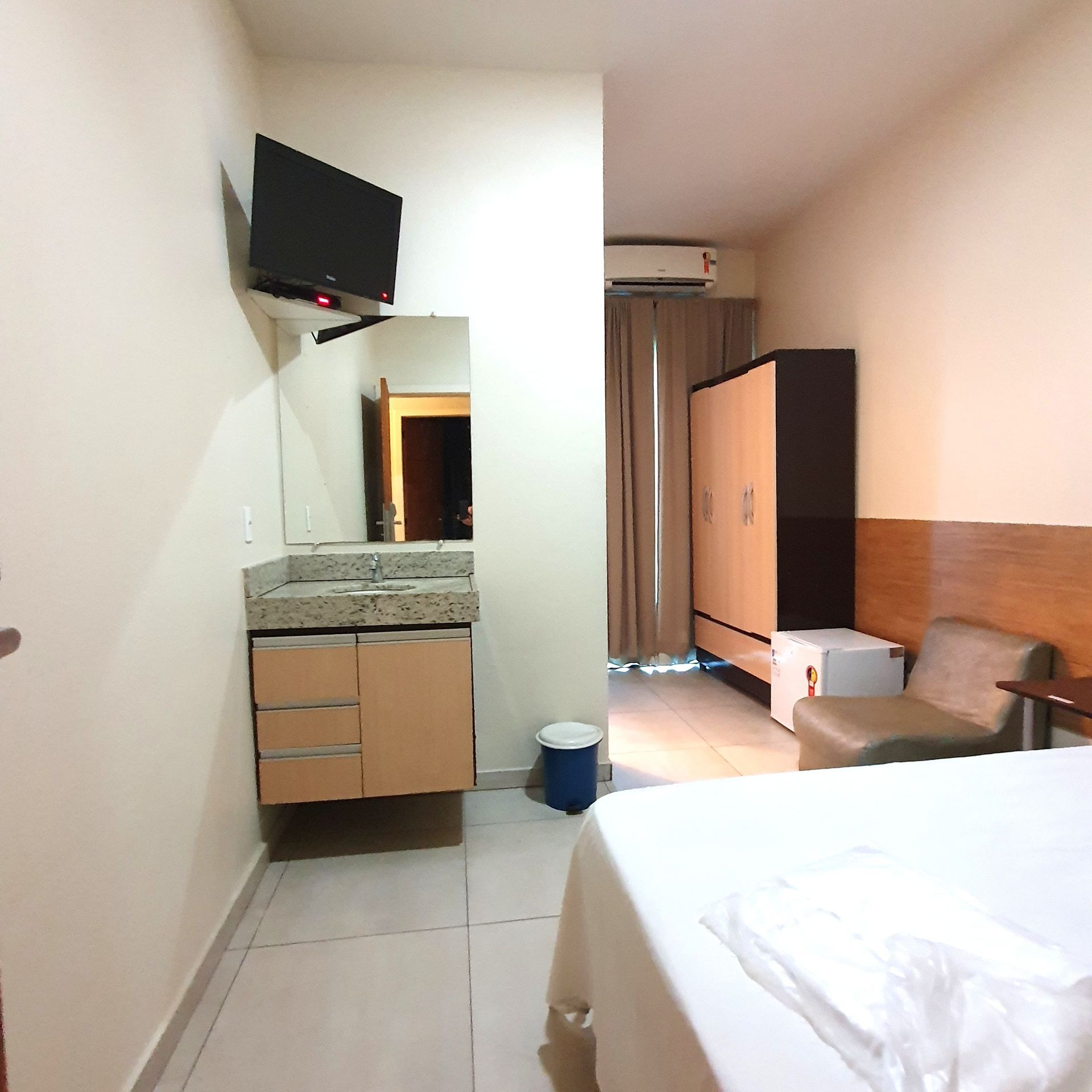 Um quarto de hotel com uma cama e uma televisão