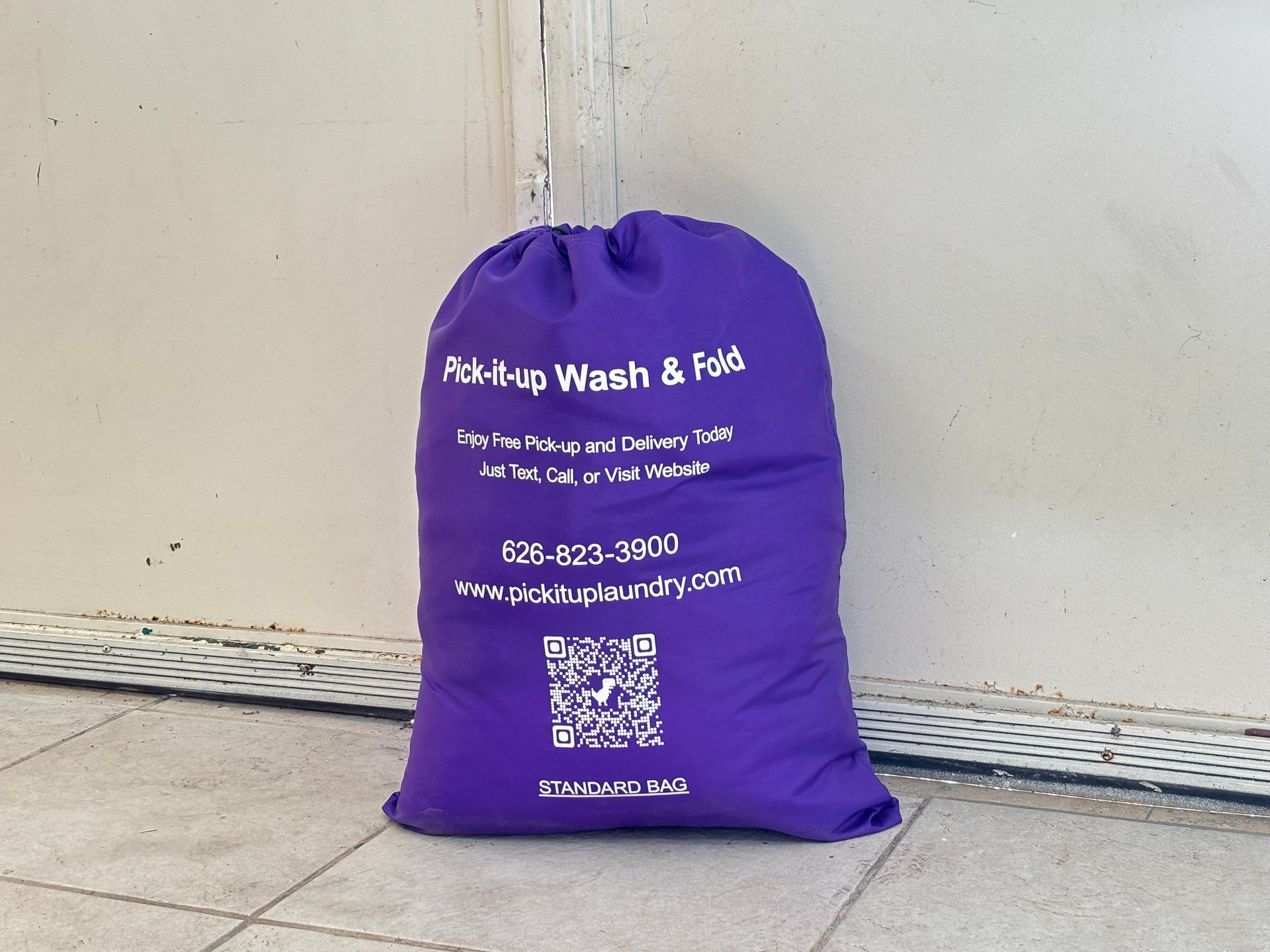Purple laundry bag with drawstring, labeled 