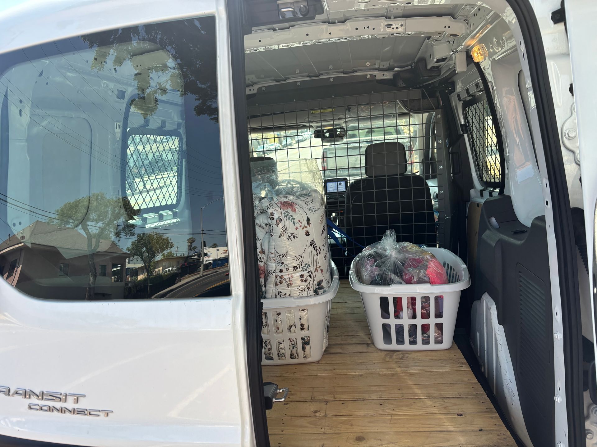 White van with laundry baskets inside, likely for a laundry service.
