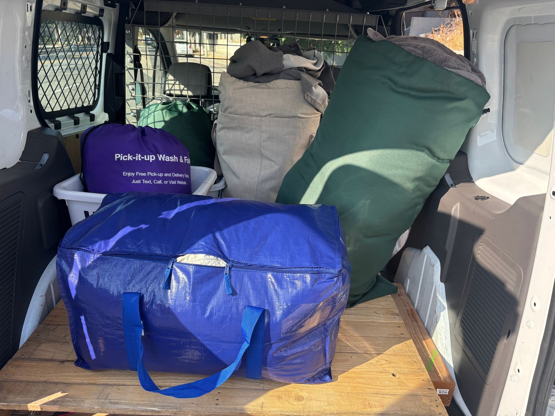 White van with laundry baskets inside, likely for a laundry service.