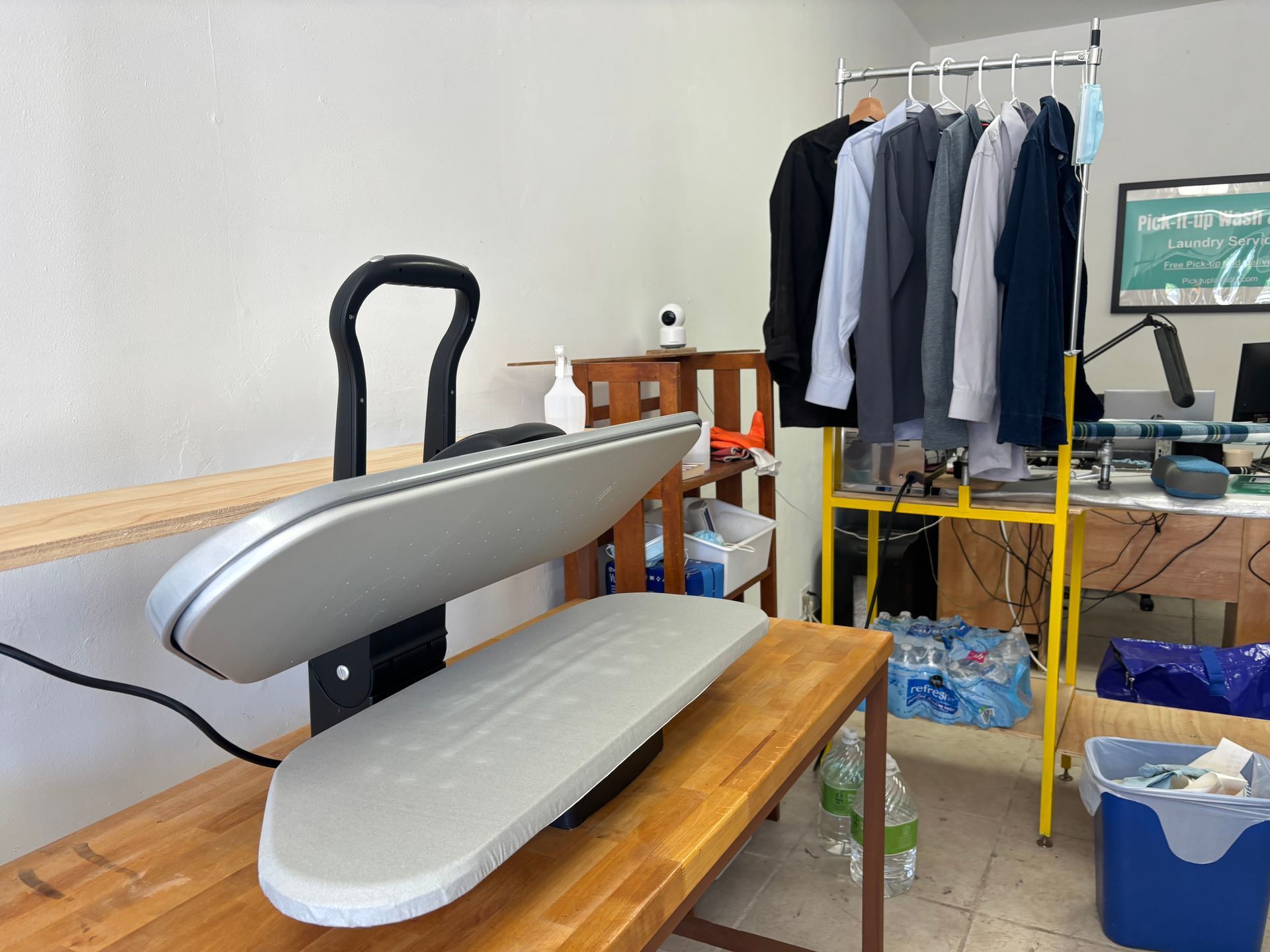 Laundry baskets filled with colorful clothes sit on a metal surface.