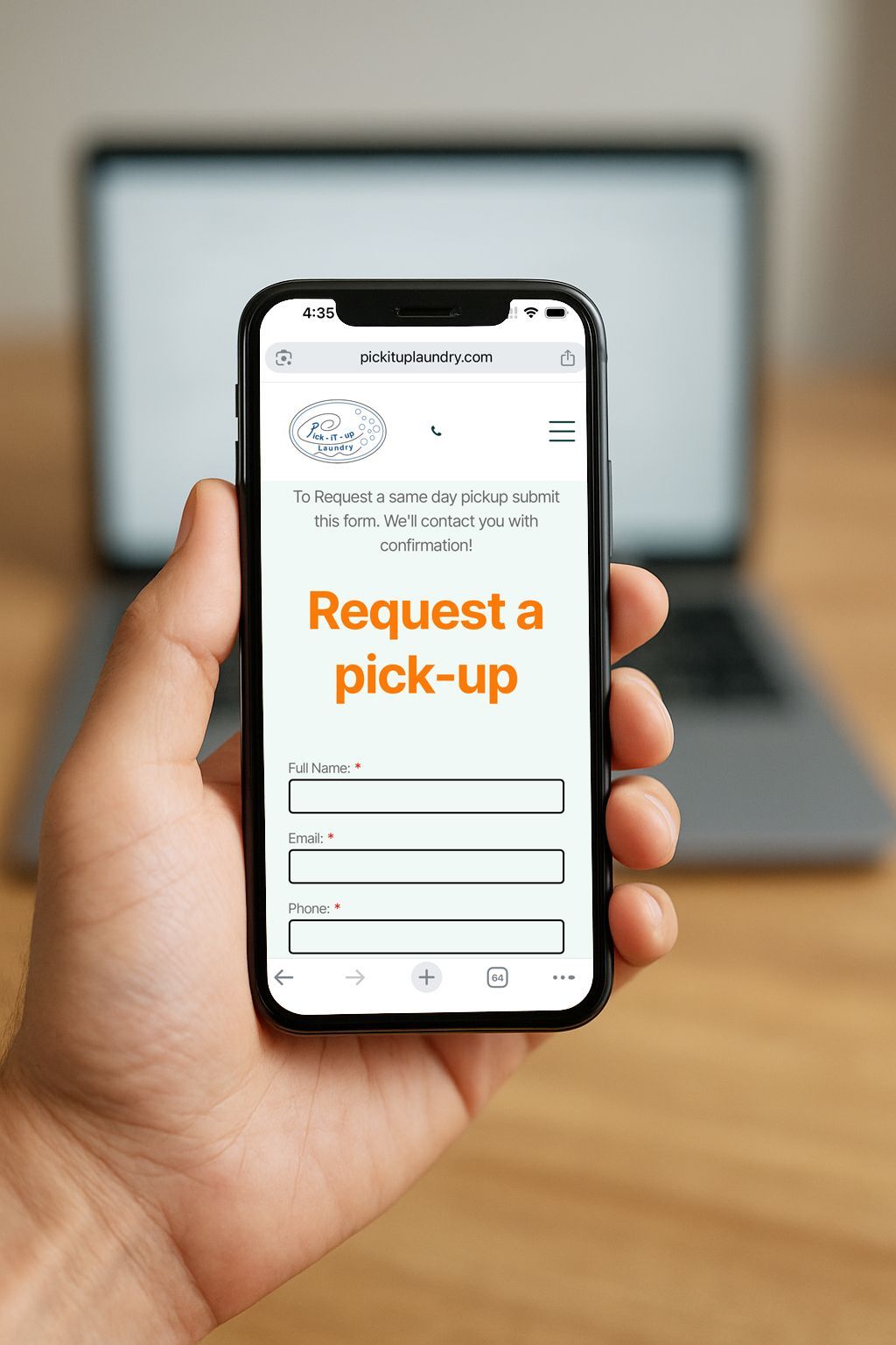 Hand holding a phone displaying a pick-up request form, with a laptop in the blurred background.