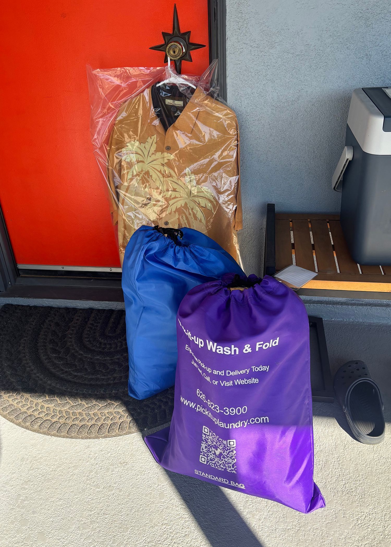 Wrapped blankets on a table, shelves with storage bags in background.