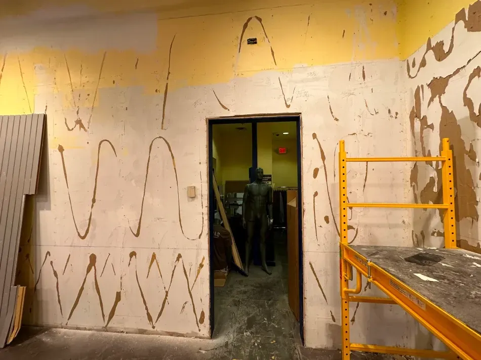 Room undergoing renovation with exposed wall, doorway, and scaffolding.
