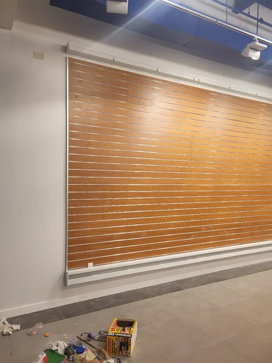 Brown and white horizontal blinds covering a large window. Installed in a modern interior.
