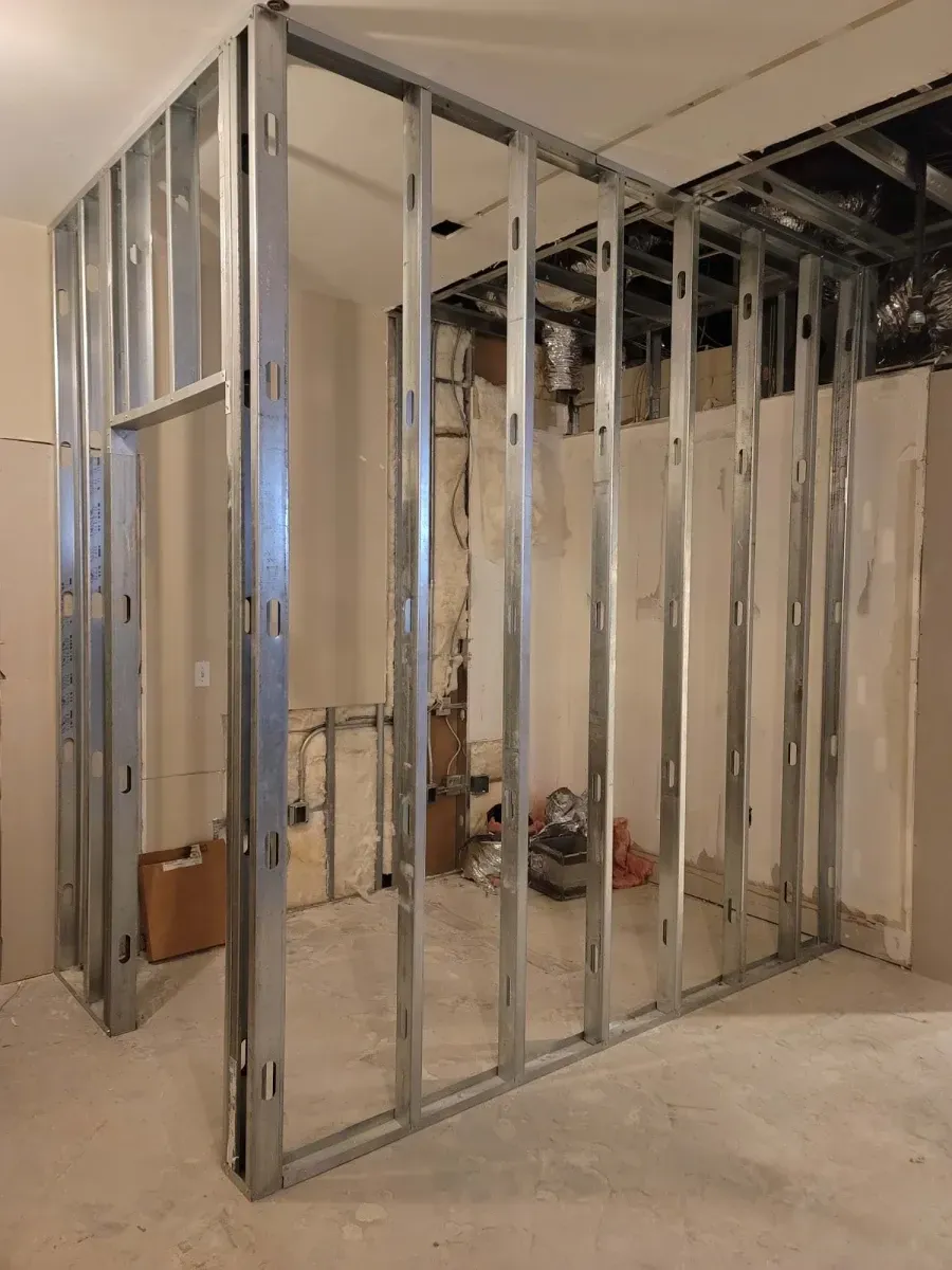 Metal stud framing of a room under construction, with an open doorway.