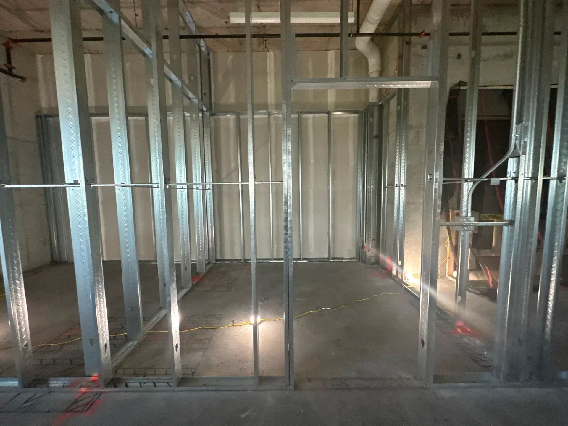 Metal stud framing for interior walls in a room, under construction.