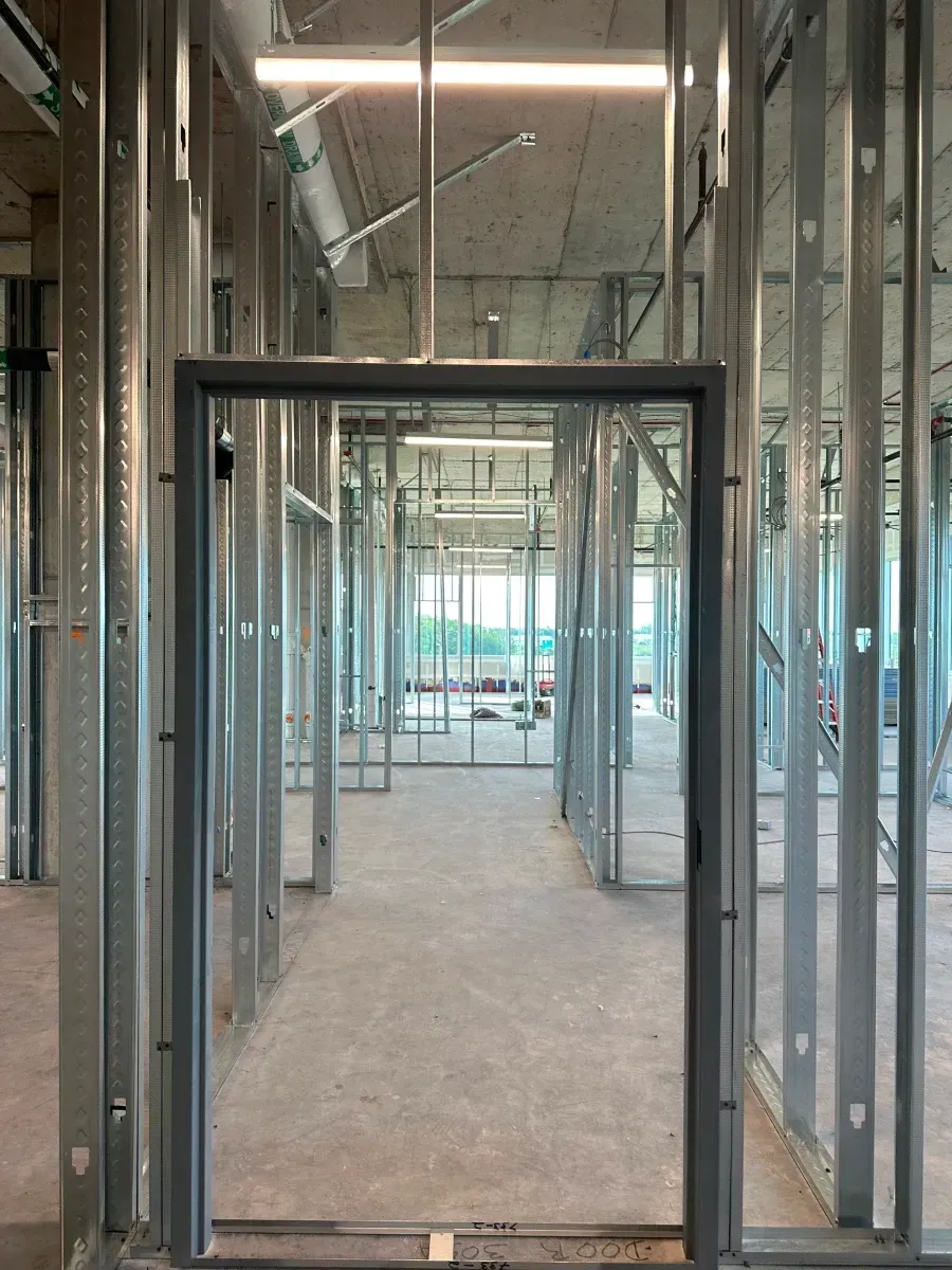 Interior construction site, metal frame doorway in a hallway, unfinished.
