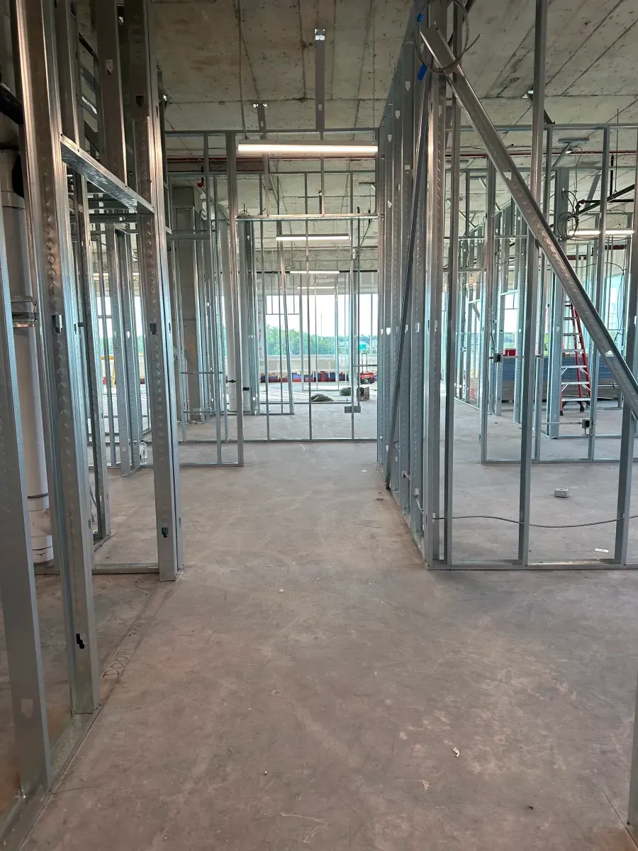 Interior of a building under construction, metal framing on concrete floor.