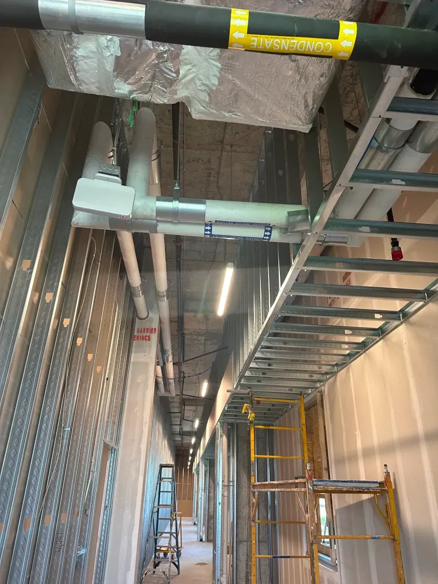 Construction of a hallway: metal framing, pipes, and scaffolding.
