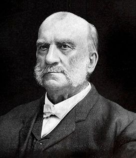 Portrait of Lord Lister, with a white mustache and mutton chops, wearing a dark suit and white bowtie against a dark background.