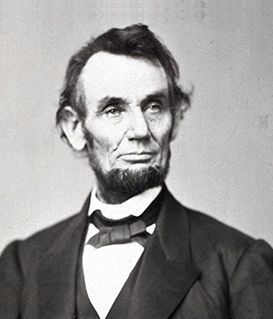 A formal black-and-white portrait of Abraham Lincoln, shown from the chest up wearing a suit and bowtie.