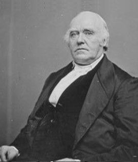 A black-and-white portrait of John Quincy Adams in a formal suit and vest, looking directly forward with a serious gaze.
