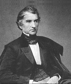 A monochromatic studio portrait of Justus von Liebig, depicted from the chest up in 19th-century formal attire.