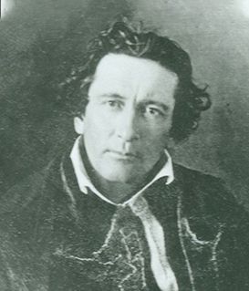 A black-and-white portrait of a person with wavy hair, wearing a dark coat with a light-colored cravat.
