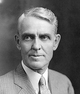 Black-and-white portrait of Edward M. House, wearing a suit and tie, against a dark, plain background.