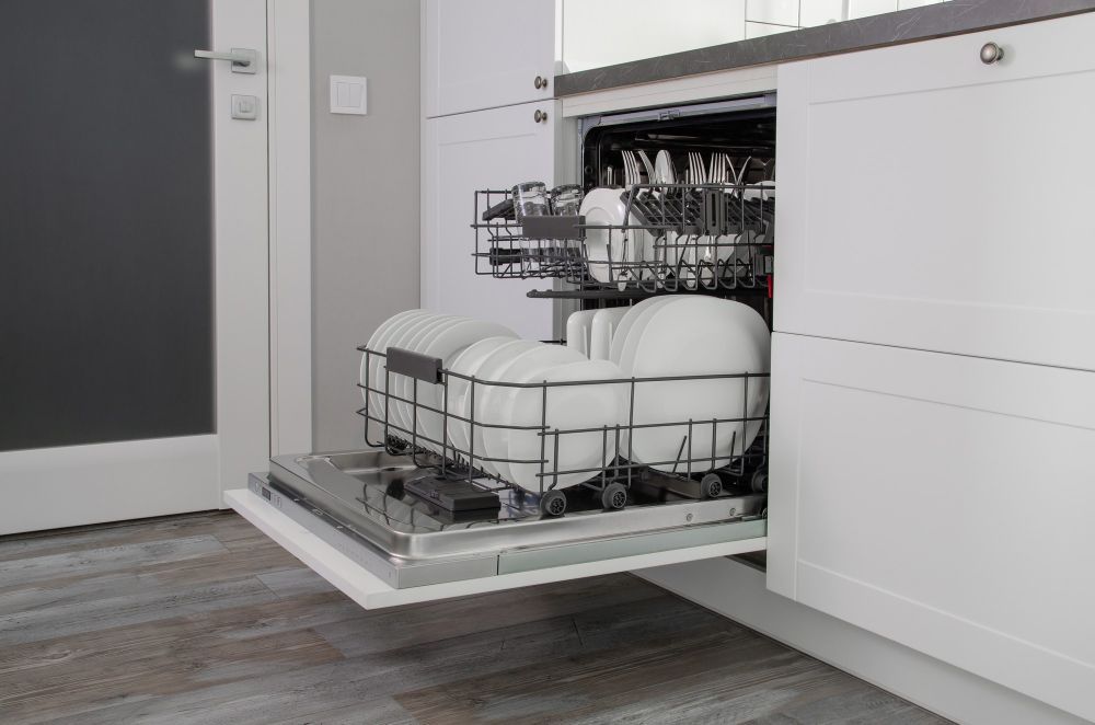A Dishwasher Is Filled With Plates And Cups In A Kitchen