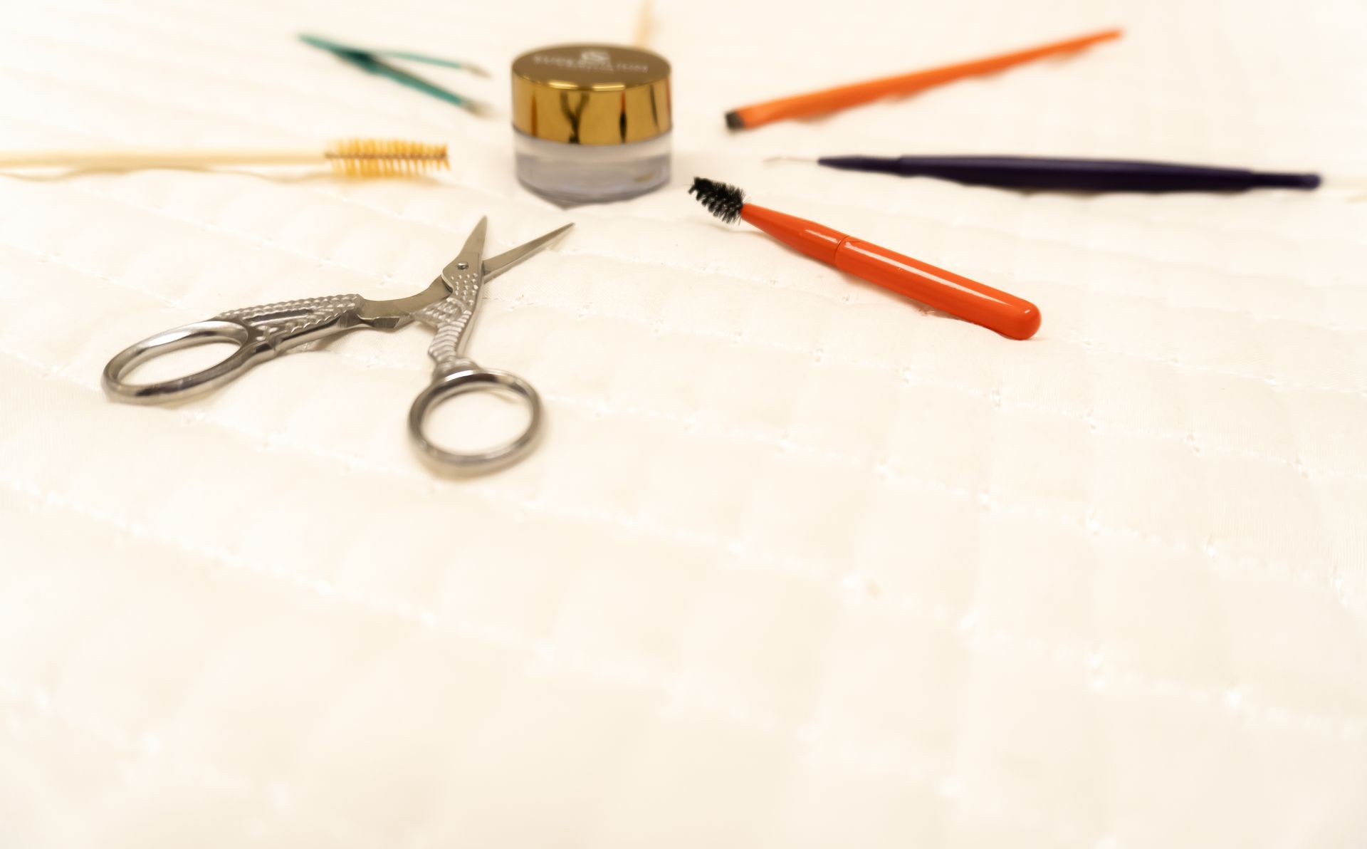 A pair of scissors is surrounded by other tools on a table