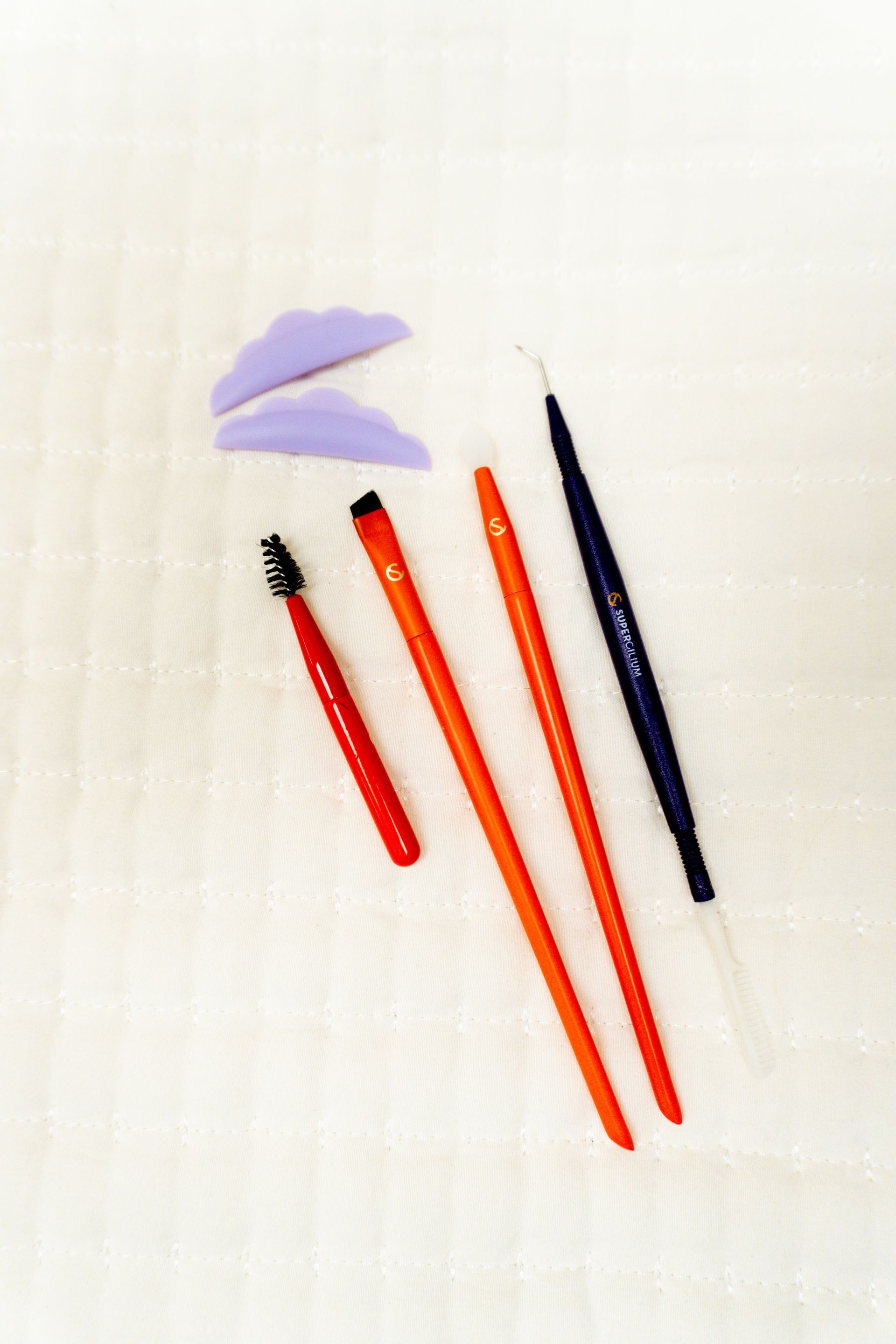 A set of makeup brushes and sponges on a white surface.