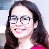 Kvinne med briller som smiler, iført en rød skjorte.