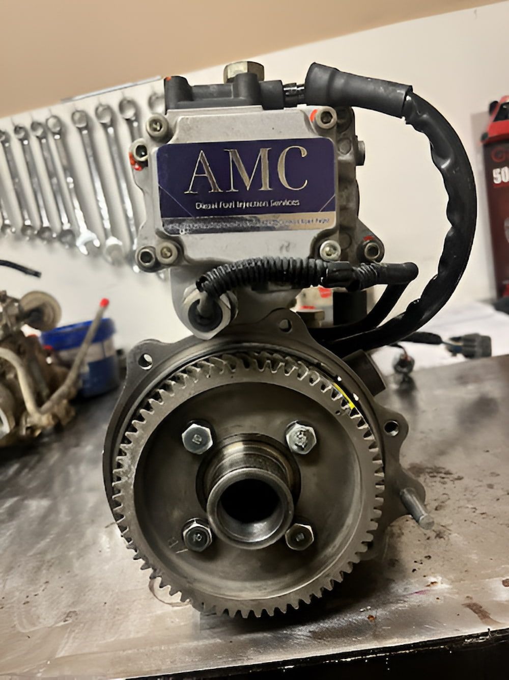 A Fuel Pump With A Gear Attached To It Is Sitting On A Table — AMC Diesel Fuel Injection Services In Paget, QLD
