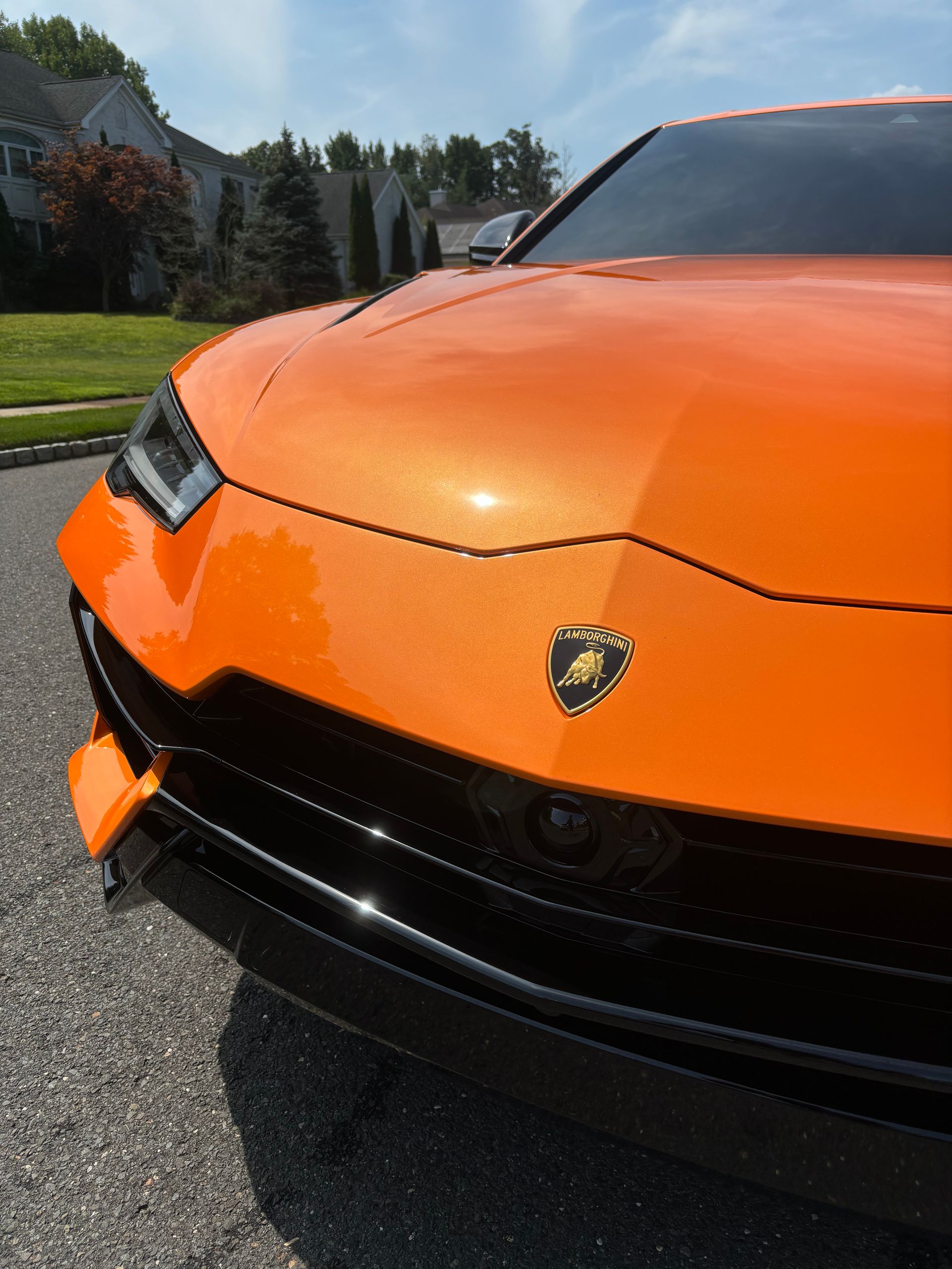 Orange Lamborghini exterior freshly detailed with ceramic coating for a mirror-gloss finish.