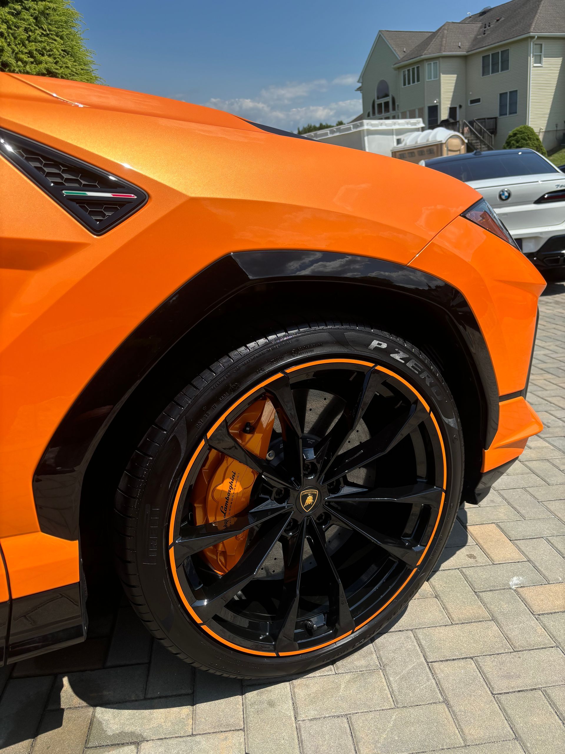 Orange Lamborghini Urus side view after exterior detailing and ceramic coating service.