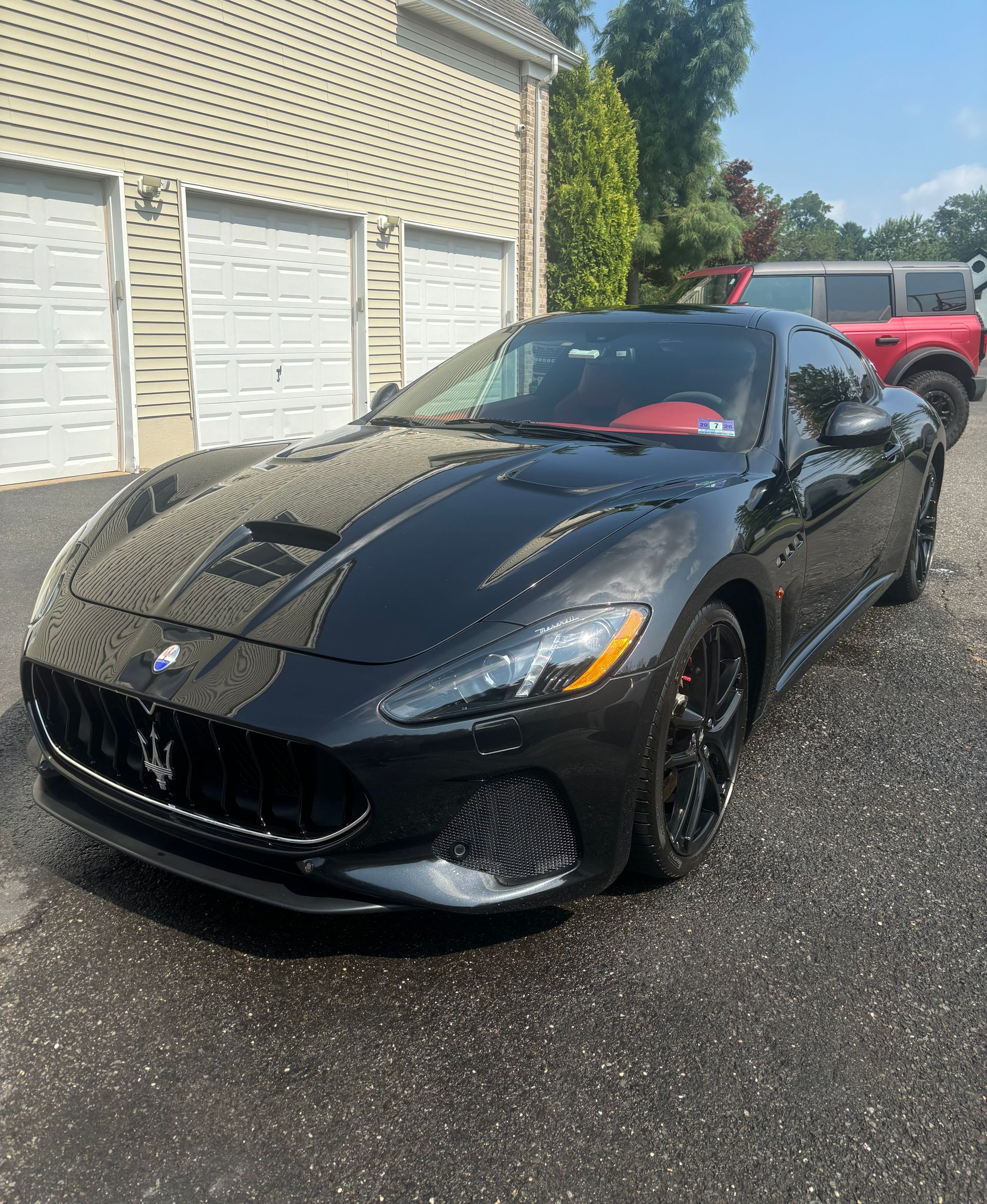 Black sports car exterior polished to high gloss after ceramic coating in New Jersey.