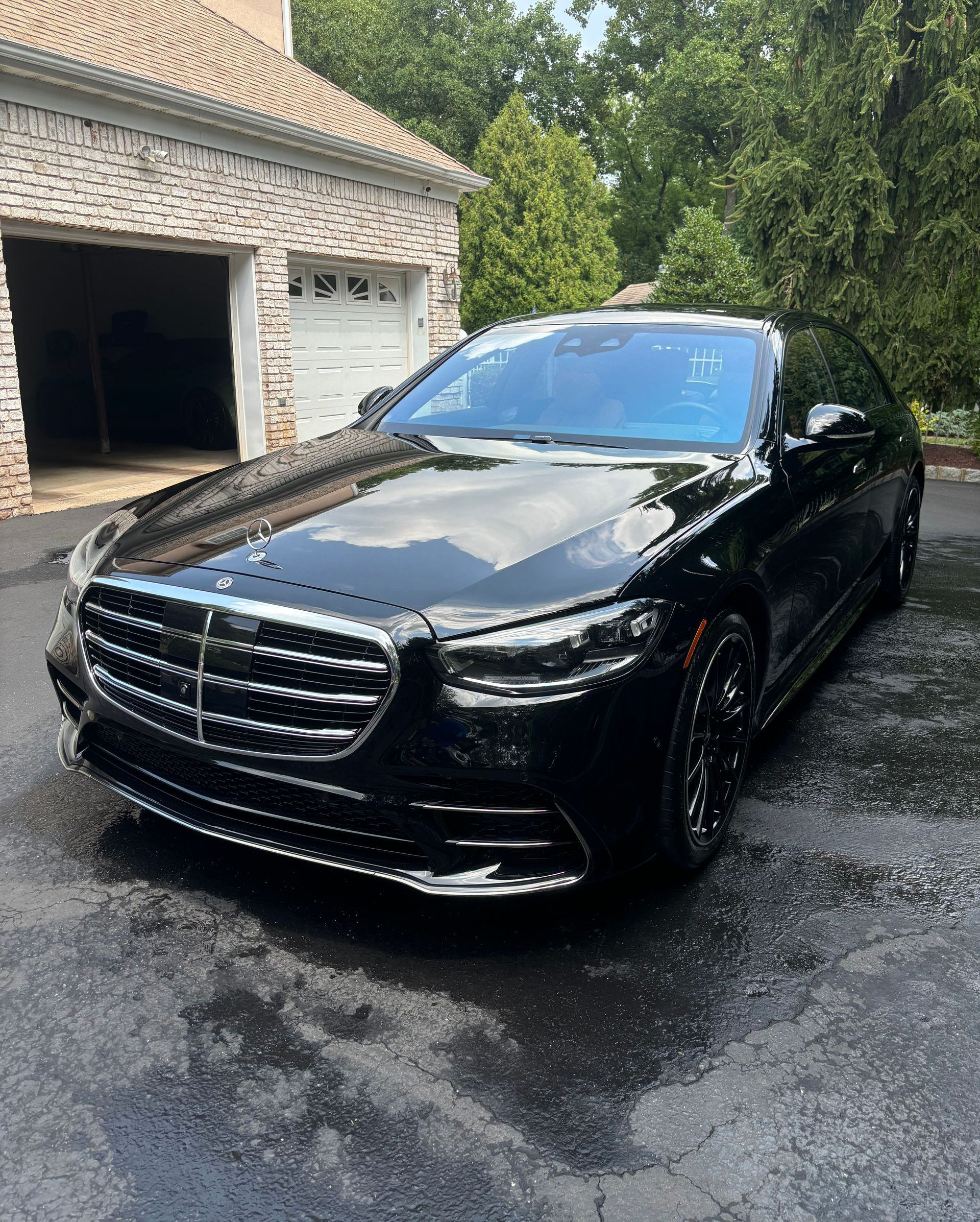 Luxury black car freshly detailed and waxed, showing flawless mirror-like reflection.