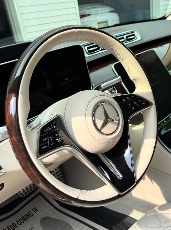 Clean white leather steering wheel and dashboard after luxury interior detailing treatment.