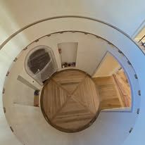 Overhead view of a circular room with wood floors and a doorway.