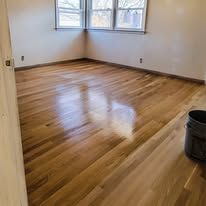Hardwood floor in a room, with sunlight reflecting off its polished surface.