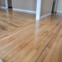 Close-up of a hardwood floor with light brown planks, angled at the edge.
