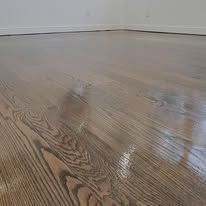 Newly finished hardwood floor, showing light brown wood grain and a glossy finish.