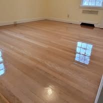 Glossy hardwood floor with natural light reflecting from a window.