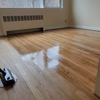 Close-up of polished hardwood flooring. Light reflects off the surface, creating shine.