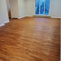 Hardwood floor in an empty room, leading toward a window.