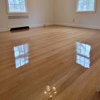 Reflective wooden floor with sunlight reflecting the window.