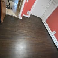 Dark wood floor, red wall, and a doorway.