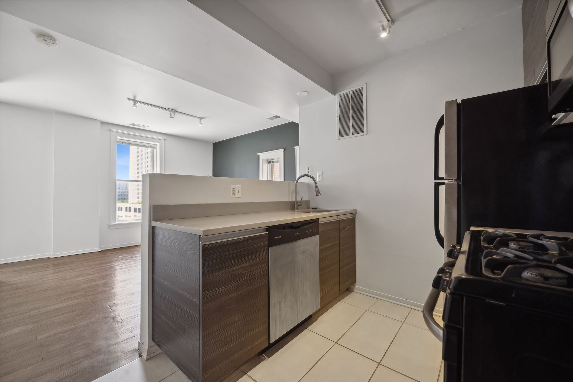A kitchen with a stove , refrigerator , dishwasher and sink.