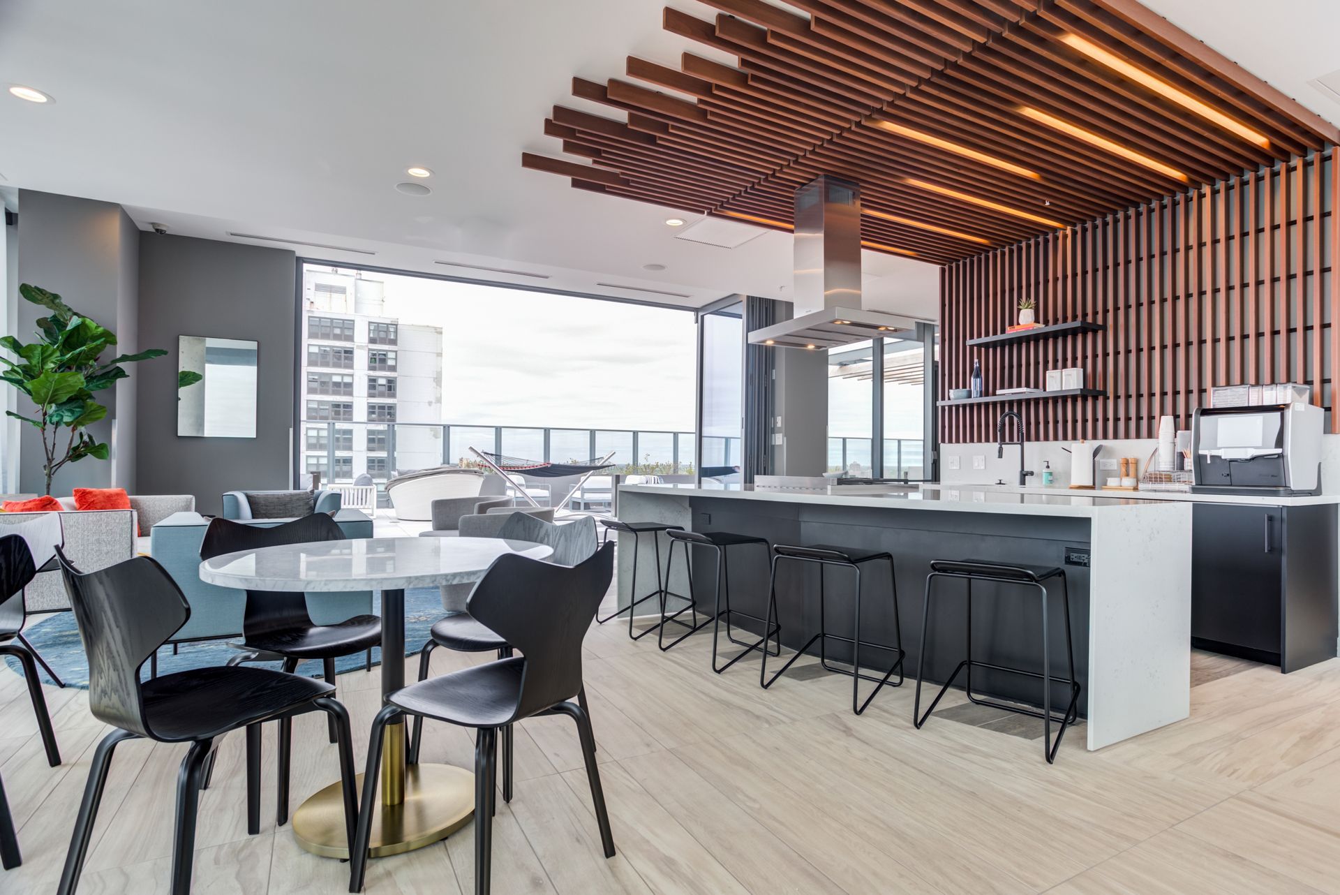 A large room with tables and chairs and a kitchen.