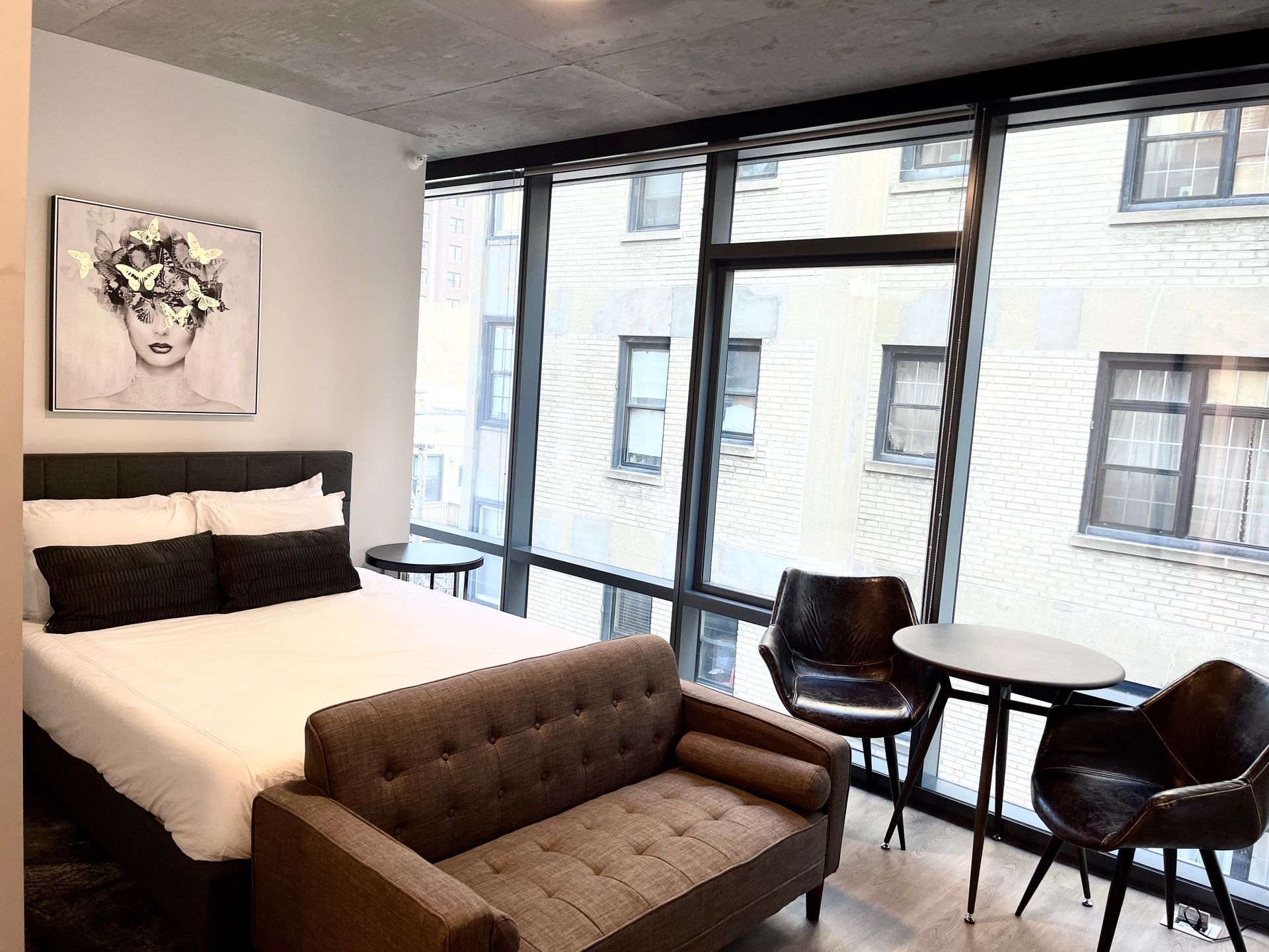 A bedroom with a bed , couch , table and chairs.