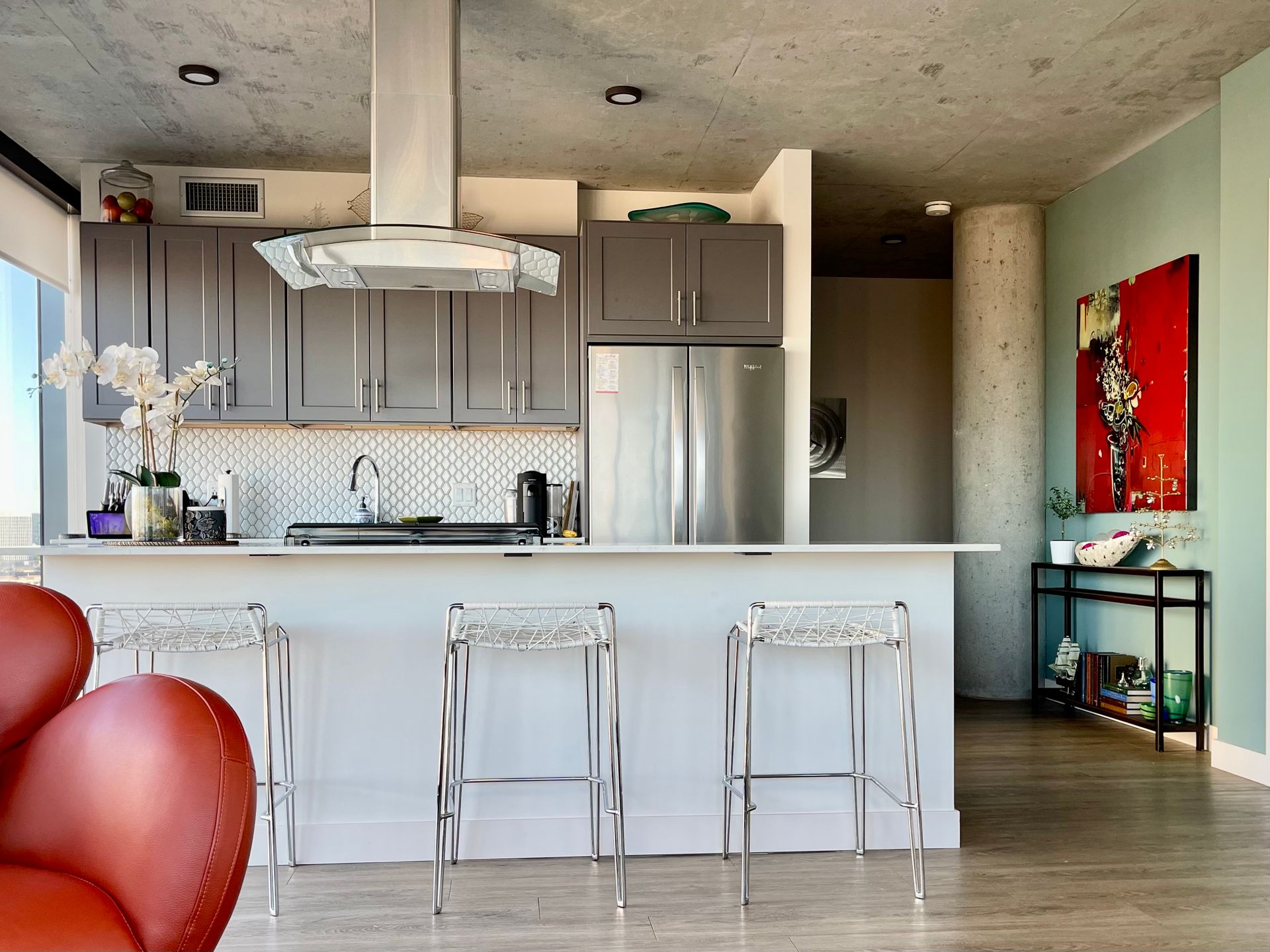 A kitchen with gray cabinets and stainless steel appliances