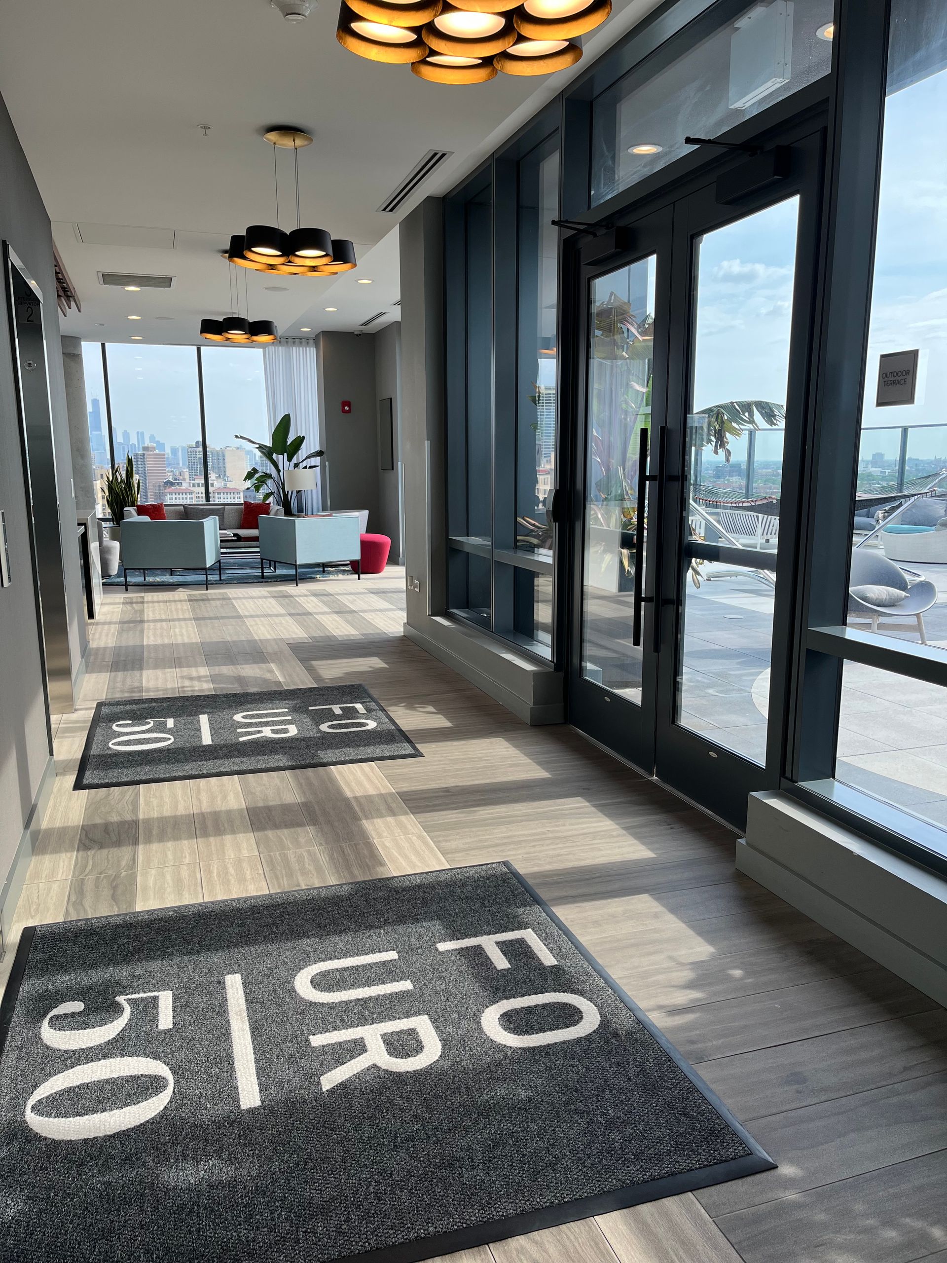 A hallway with a rug that says ' for us ' on it