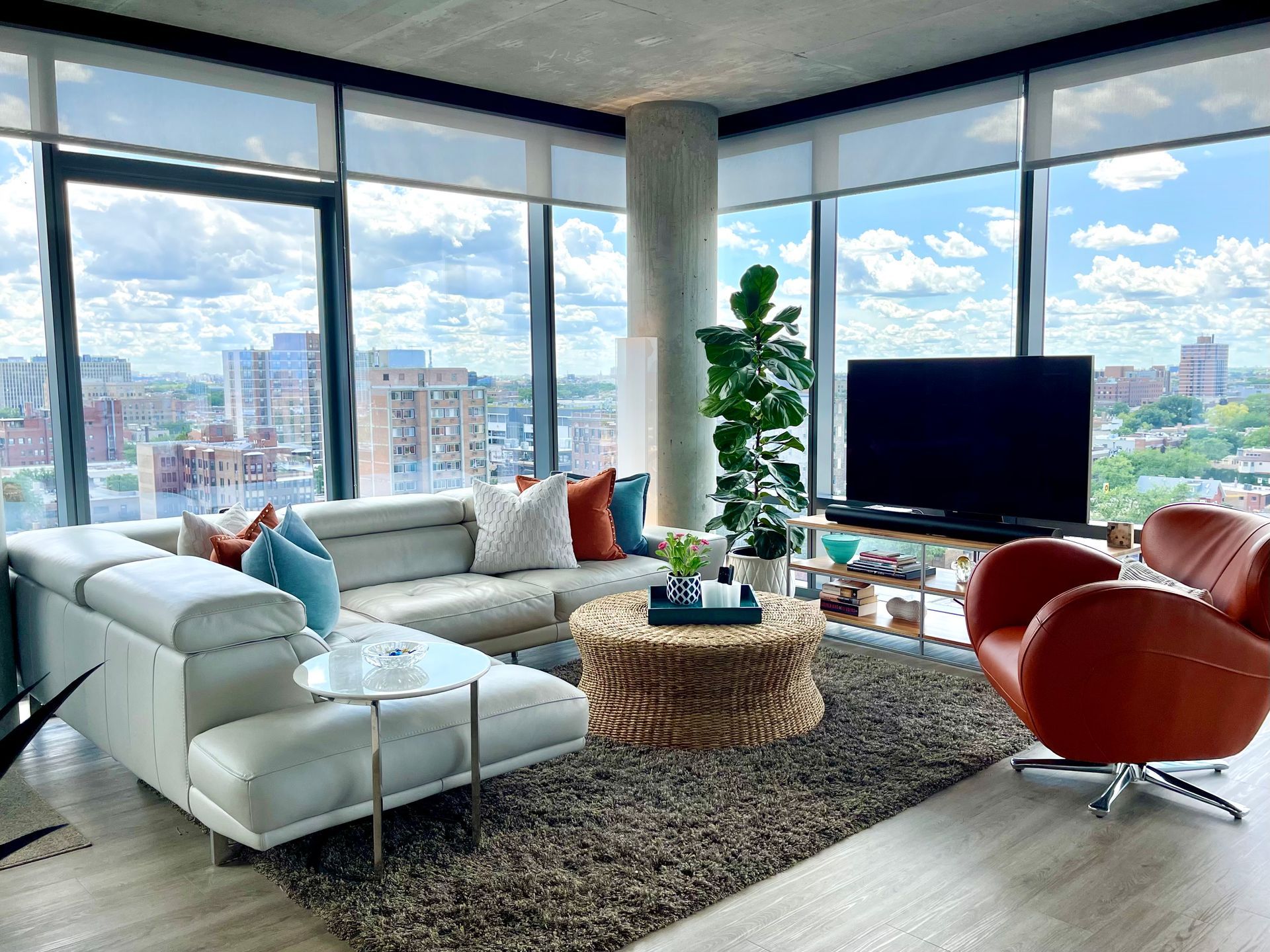 A living room with a couch , chairs , coffee table and television.