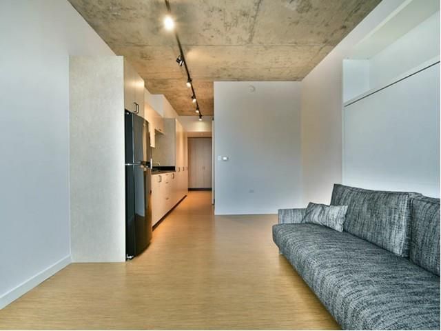 A living room with a couch and a refrigerator