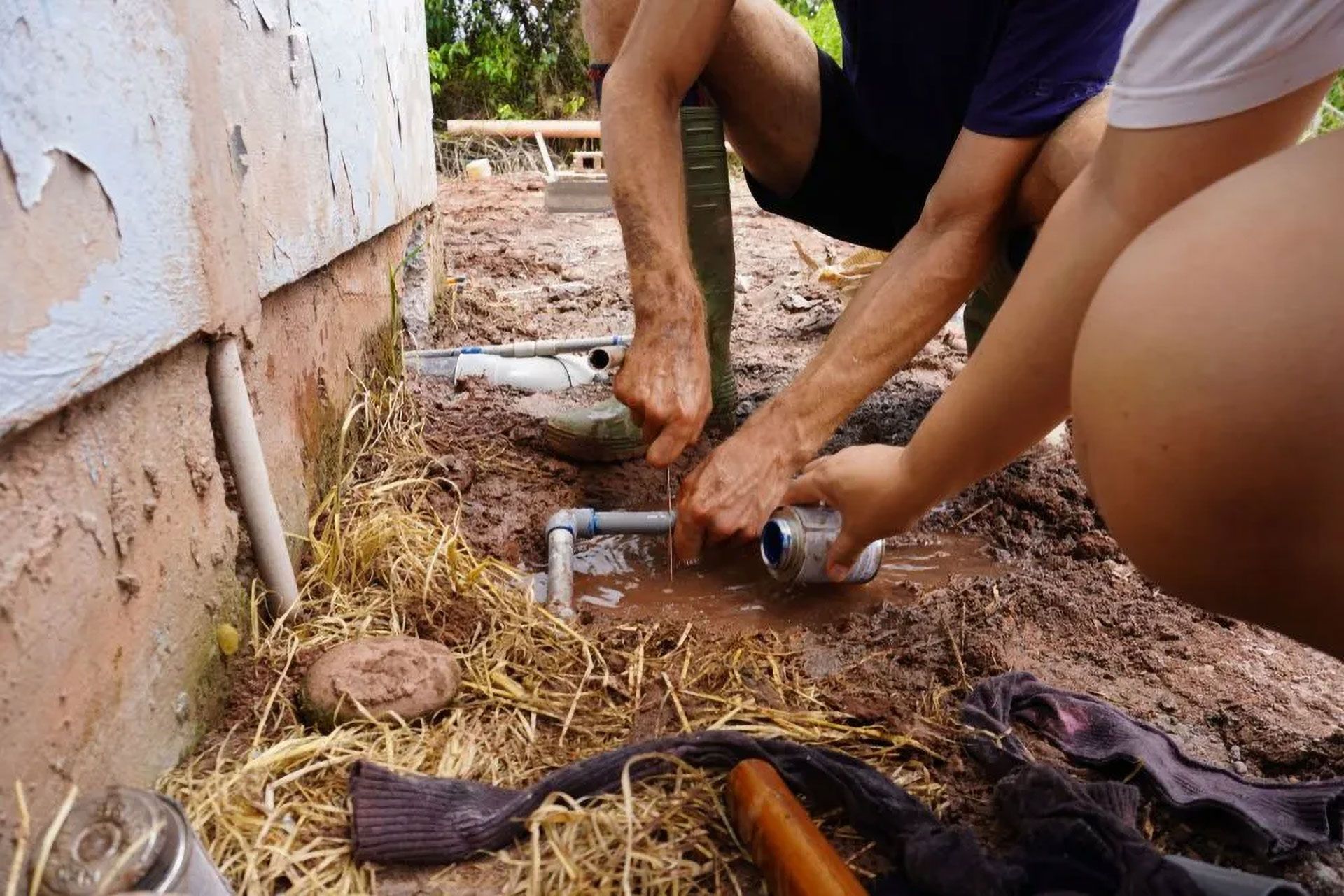 Two People Working on Outdoor Plumbing Near a Building — Full On Plumbing & Gas in Winnellie, NT
